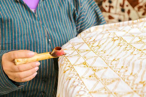 Mittelteil der Frau, die Batik auf Textil herstellt
