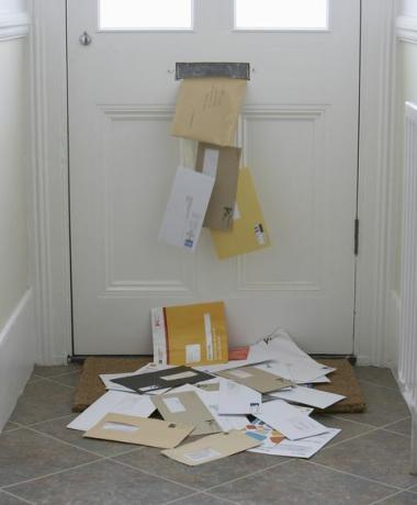 paštas nukrito nuo pašto dėžutės ant durų kilimėlio