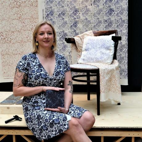 Annelise Payne stă lângă un scaun cu țesătură, tânăr designer de designer verde grad 23
