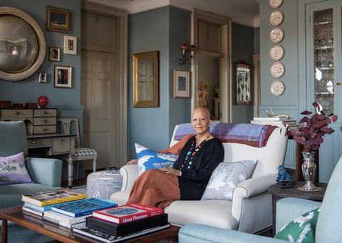 Шейла Бриджес сидит в гостиной с декоративными подушками и изображает ее harlem toile de jouy