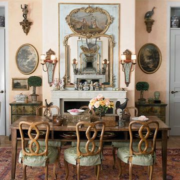 matsal med patinafärgade inklädda stolar och spegel ovanför manteln