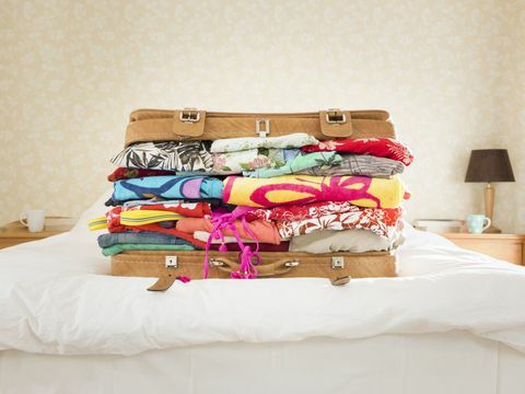 Υπερσυσκευασμένη βαλίτσα στο κρεβάτι, προαστιακό σπίτι