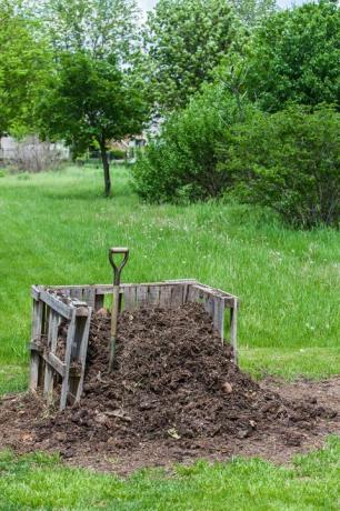 een stapel compost in een zelfgemaakte bak in de achtertuin in il