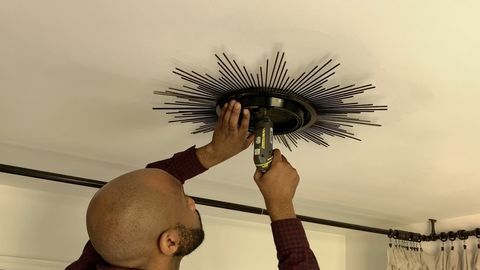 天井に鏡を掘削する男