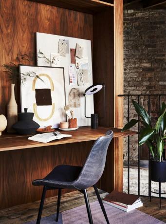 kontorsutrymme i mörkt trä i valnöt, skrivbord med en mörkgrå stol prover av tyger fästa på en artistisk licens För visuell inspiration, samla bitar som tilltalar såsom bilder, kort och tyg och visa dem på en anslagstavla