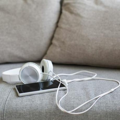 fone de ouvido e smartphone no sofá