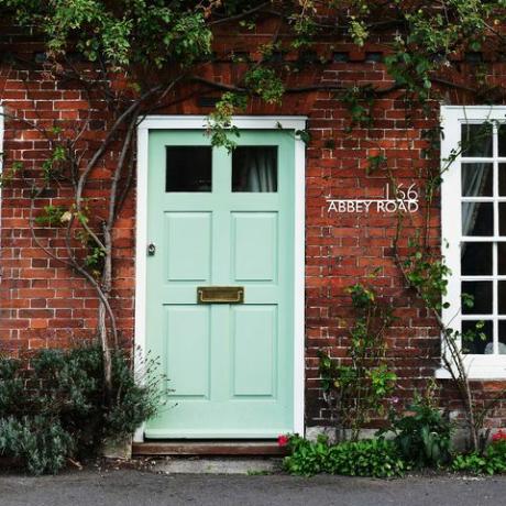 πράσινη πόρτα μέντας με εξατομικευμένη πινακίδα αριθμού σπιτιού