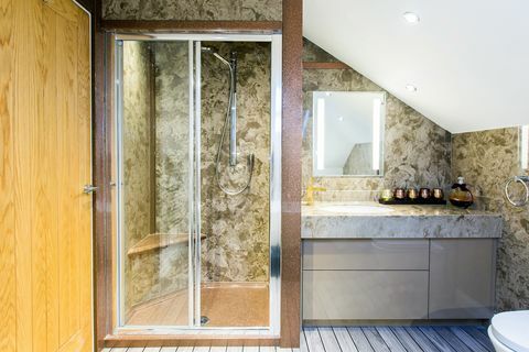 Badezimmer mit grünen Marmorwänden und gestreiftem Plattenboden