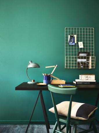 zöld kékeszöld falak az íróasztal és a zöld szék mögött, bőséges iroda, a gazdag kékeszöld szín békés és stílusos hátteret képez a praktikus munkaterületnek