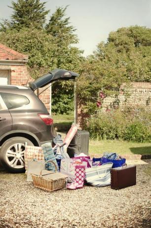 Automobilio bagažinė atidaryta su lagaminais, krepšeliais ir krepšiais, paruoštais važiuojant