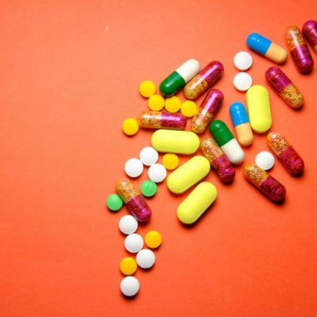 kolorowe tabletki rozlane na niebieskim tle.