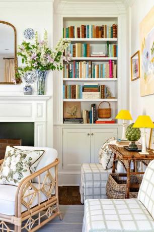 მისაღები ოთახი, თეთრი და მწვანე კალთებიანი სკამები, თეთრი ჩაშენებული წიგნების თარო, ბუხარი