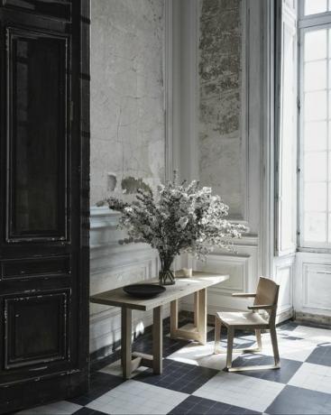 skrivebord og stol med blomster i vase på toppen af ​​bordet
