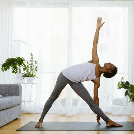 Жінка практикує йогу вдома