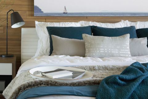 Blaugrüne und weiße Bettwäsche und Kissen im Schlafzimmer