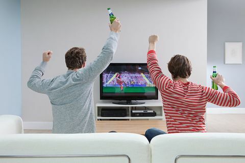 Dvaja muži sledujú futbal v televízii