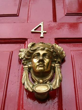 Црвена врата број четири са златном лупком за главу