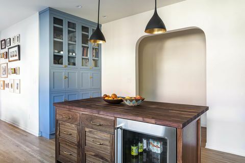 Weiße Küche mit Rundbogen und Kochblockinsel aus dunklem Holz