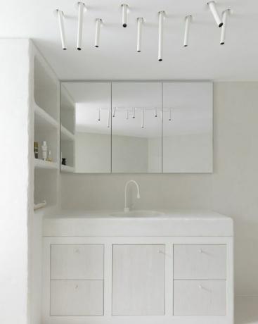 חדר רחצה לבן מודרני עם תאורת סטייטמנט