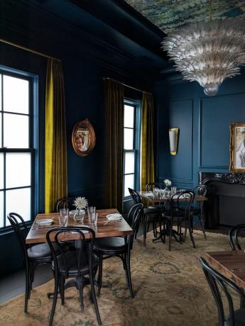 სასადილო ოთახი მუქი ლურჯი კედლებით და ოქროს ფარდებით