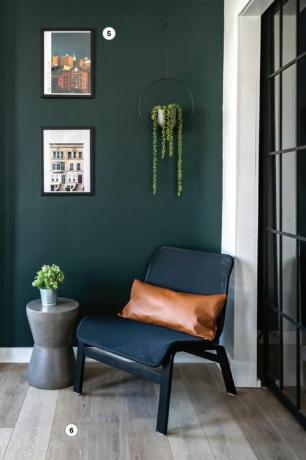 kącik do czytania z zieloną ścianą i czarnym krzesłem