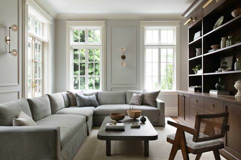 familjerum, specialanpassad bokhylla i trä, kronlist, lampetter, grå soffa