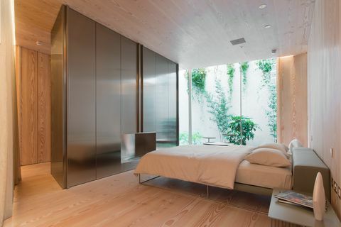 Modernt sovrum med dubbelsäng och fönster från golv till tak