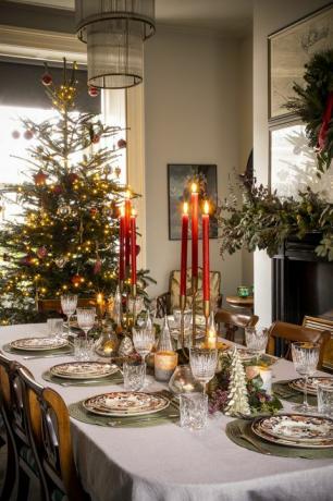 Kalėdų stalo puošmena su raudonomis žvakėmis