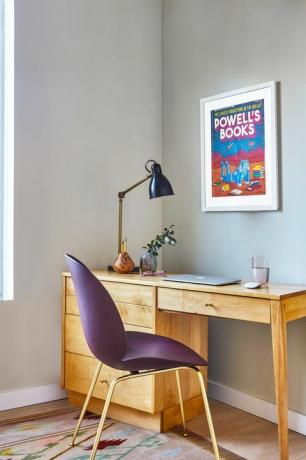 namų biuras su mediniu stalu ir purpurine kėde