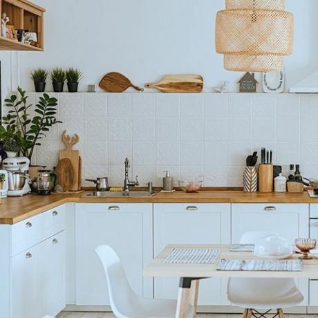 Interior acogedor de cocina moderna de estilo escandinavo con zona de comedor, interior moderno blanco
