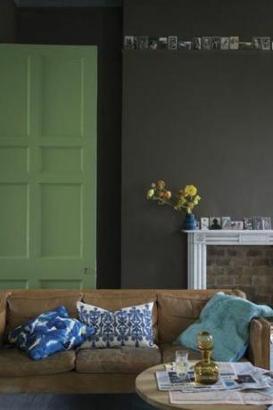 Soggiorno con porta verde dipinto in emulsione immobiliare Yeabridge Green di Farrow & Ball