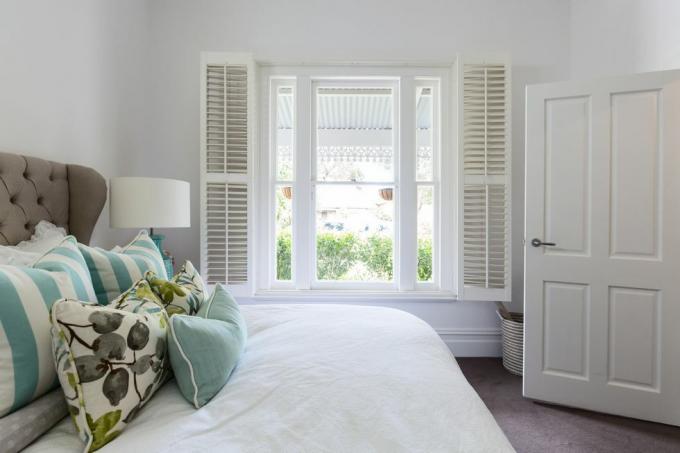 Schlafzimmerfenster mit Gartenblick in einem luxuriösen Landhausschlafzimmer