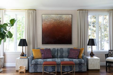Popolnoma opremljena dnevna soba Chloe Warner z modrim kavčem in slikami na steni
