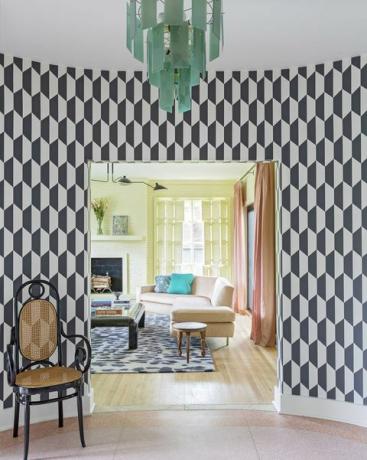 家への玄関、黒と白の幾何学的な壁紙、黒と茶色の椅子