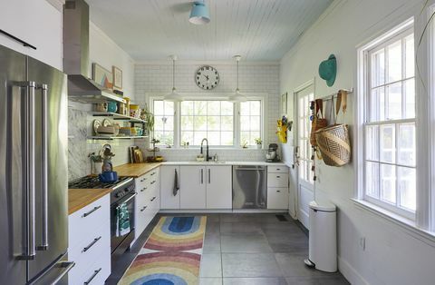Küche, weiße Küchenschränke, Holzarbeitsplatte, weiße U-Bahn-Fliesen, Edelstahlgeräte