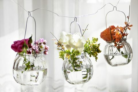 Tres vasos colgantes con flores frescas.