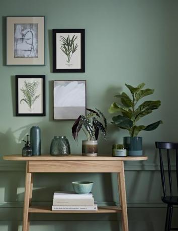 stylowy pokój z zieloną farbą i drewnianym kredensem
