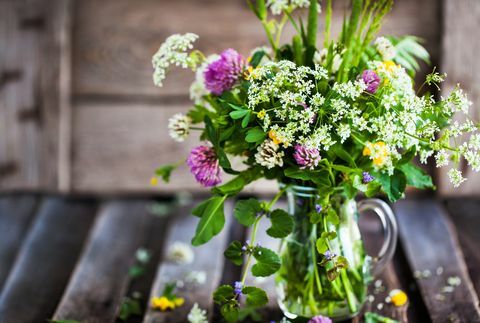 Kukkakimppu luonnonkukkia lasipurkissa puupöydällä, kesäkonsepti