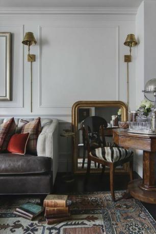 sala de estar, tapete marroquino, sofá de couro marrom, cadeira de jantar de madeira com capa de almofada zebra