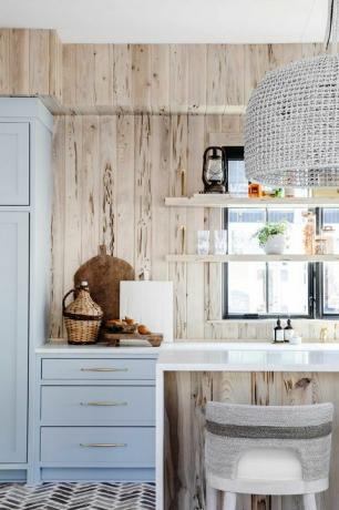 cocina, gabinetes azules, encimeras blancas con placa para salpicaduras de madera
