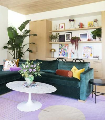zöld kanapé, lila szőnyeg