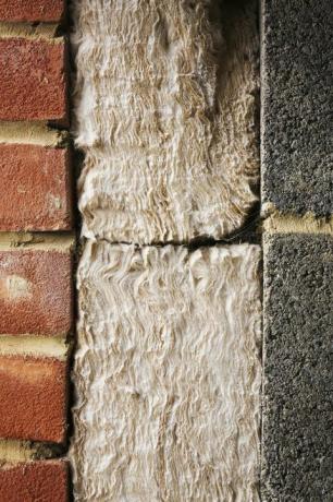 Nærbilde av isolasjon mellom en murvegg og mursteinblokkvegg.