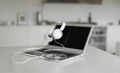 Laptop, headphone, dan CD di atas meja