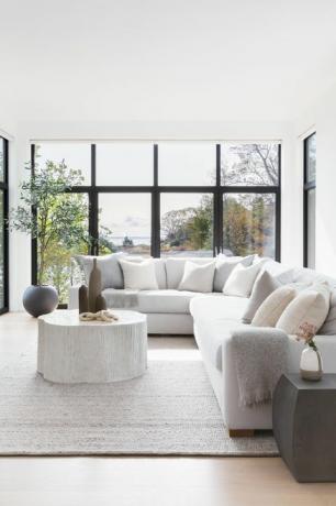 divano grigio, tavolino in legno, tappeto grigio, plaid grigio, ante in vetro