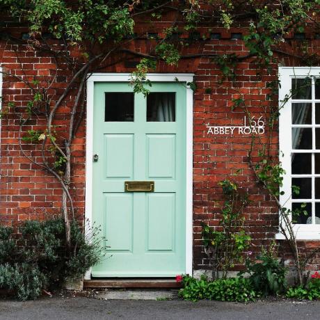 drzwi wejściowe w kolorze miętowej zieleni drzwi z indywidualnym szyldem z numerem domu