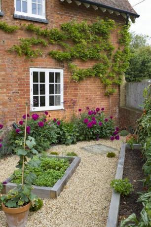 mažas angliškas kiemo sodas Jungtinėje Karalystėje su ąžuolinėmis miegamosiomis lovomis, žvyru ir Viktorijos laikų namais