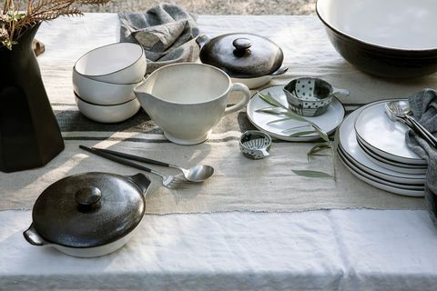 melnbalti keramikas trauki uz lina galdauta ārā