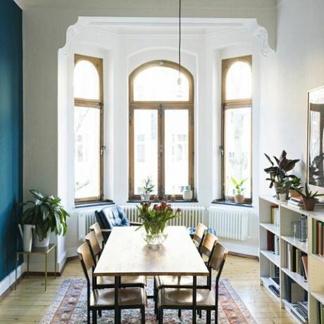 Bord og stoler i tre i moderne stue med stort vindusfront i stilig leilighet