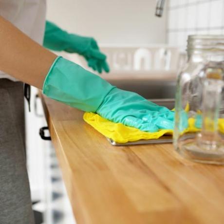 srednji dio žene koja čisti kuhinjski pult