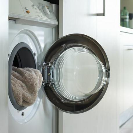 Detail ručníku v pračce, s otevřenými dveřmi pračky
